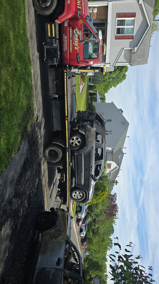 Craig's Towing & Recovery flatbed tow truck loading a burned SUV in New Castle, DE.