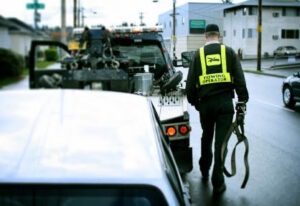 A towing operator walking to assist a vehicle with a tow truck from AE Recovery and Towing in Phoenix, AZ.