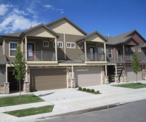 Modern townhouses featuring brown horizontal siding and decorative stone accents, completed by New Look Siding in Midvale, UT.