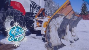 A tractor equipped with a large snow plow blade, ready for or actively engaged in snow removal by JC Snow Management in Mount Vernon, NY