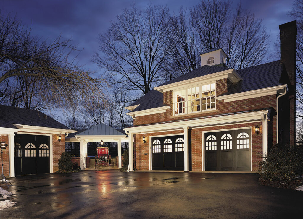 A traditional brick home with multiple black carriage-style garage doors installed by 775 Overhead Doors in Carson City, NV.