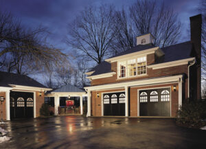 A traditional brick home with multiple black carriage-style garage doors installed by 775 Overhead Doors in Carson City, NV.