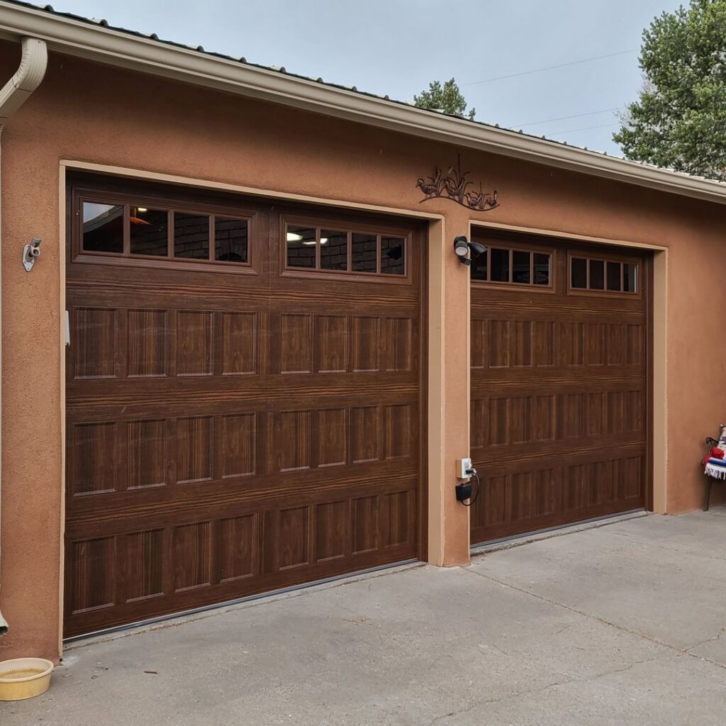 Two traditional brown garage doors with decorative windows installed by Precision Garage Door of Albuquerque and Santa Fe, NM.