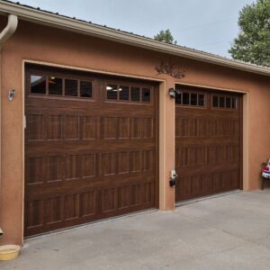 Two traditional brown garage doors with decorative windows installed by Precision Garage Door of Albuquerque and Santa Fe, NM.