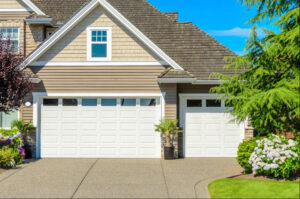 A traditional home showcasing two classic white garage doors installed by Sawtooth Garage Doors in Boise, ID.