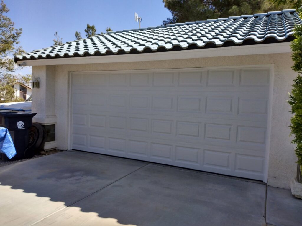 A traditional white paneled garage door installed on a home by Cactus Garage Doors, Inc. in North Las Vegas, NV.