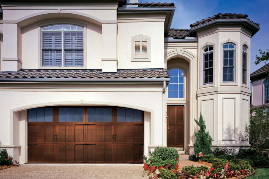 A traditional-style house featuring a large wooden garage door installed by Overhead Door Company of Little Rock in North Little Rock, AR.