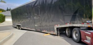 Affordable Towing LLC assisting with a large black enclosed trailer, possibly for recovery or repositioning in Anaheim, CA.