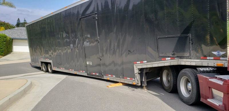 Affordable Towing LLC assisting with a large black enclosed trailer, possibly for recovery or repositioning in Anaheim, CA.