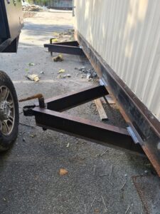 A truck's hitch connected to a trailer frame, showing towing equipment from Dyson's Mobile Repair & Hauling LLC in Virginia Beach, VA.