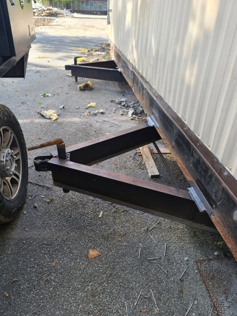 A truck's hitch connected to a trailer frame, showing towing equipment from Dyson's Mobile Repair & Hauling LLC in Virginia Beach, VA.