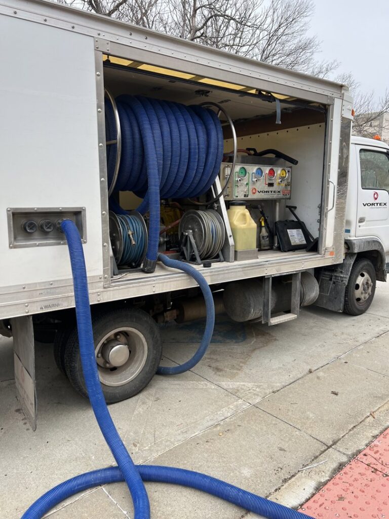 Truck-mounted water extraction unit with hoses deployed for water damage cleanup by Express Restoration in Edmond, OK.