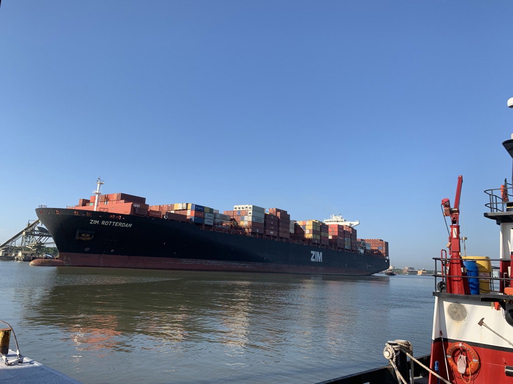 A tugboat from Myrick Marine Contracting Corp. in Norfolk, VA, assisting a large container ship on the waterway.