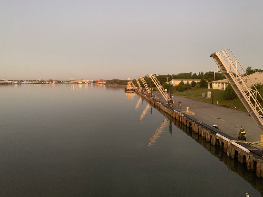 Several tugboats from Myrick Marine Contracting Corp. docked at a long pier in Norfolk, VA.