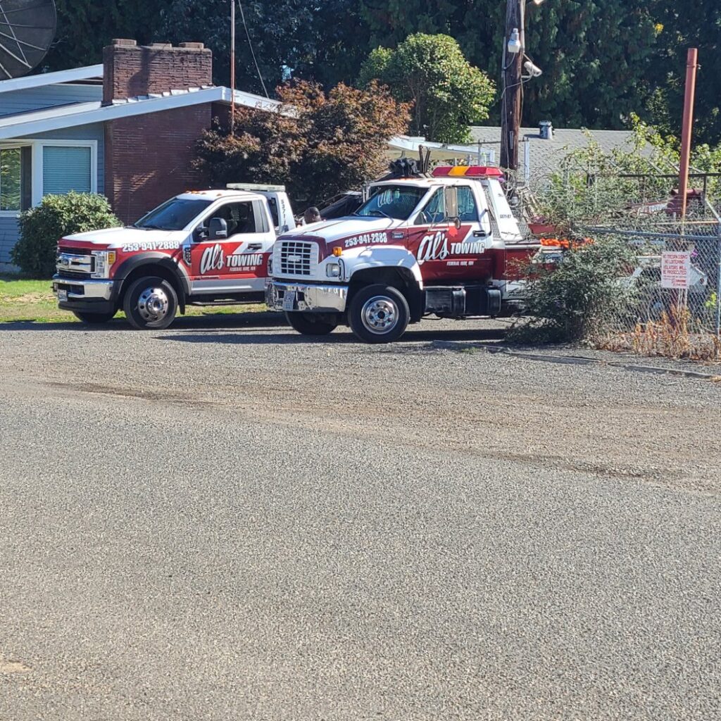 Two Al's Towing trucks, a flatbed and a wrecker, parked side-by-side in Jackson, NJ