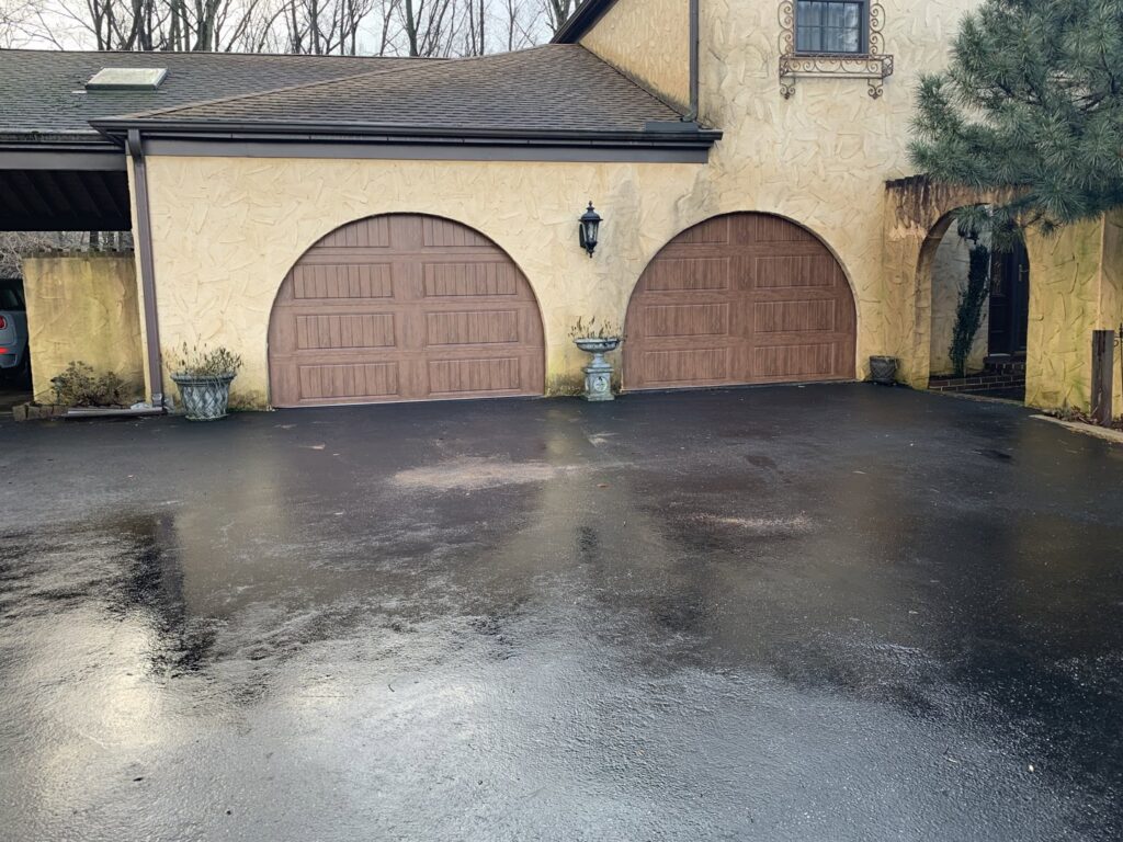 Two newly installed arched brown garage doors on a stucco residential building by 4thgenerationsdoors in Huntington, WV.