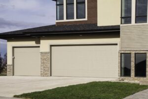 A contemporary home featuring two beige garage doors installed by Overhead Door Co of Missoula in Missoula, MT.