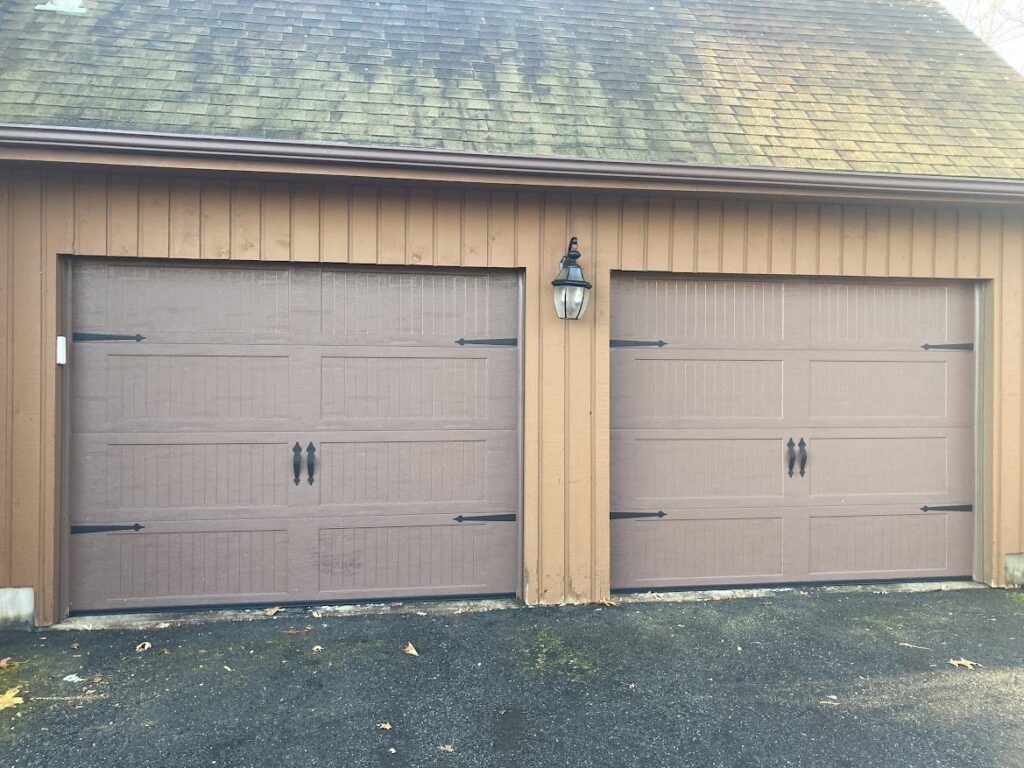 Two brown garage doors with decorative black hardware installed by Douglas Garage Door Center in East Hartford, CT.