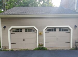Two brown garage doors with top windows installed on a residential home by Compton Doors, Inc. in Attleboro, MA