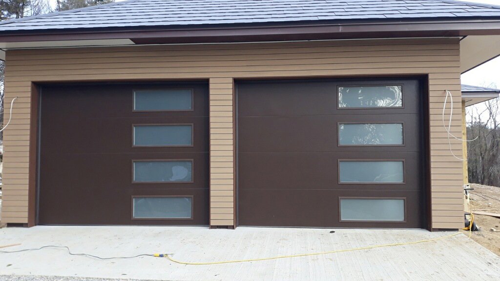 Two modern brown garage doors with frosted glass panels, a stylish option from Steve Shumsky Unlimited Overhead Doors LLC in Hudson, NH