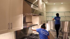 Two house cleaners from Supreme Home Cleaning, Inc meticulously cleaning a modern kitchen in Boston, MA.