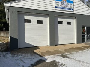 Two white commercial garage doors installed on a business building by NDI Garage Door in Plaistow, NH.