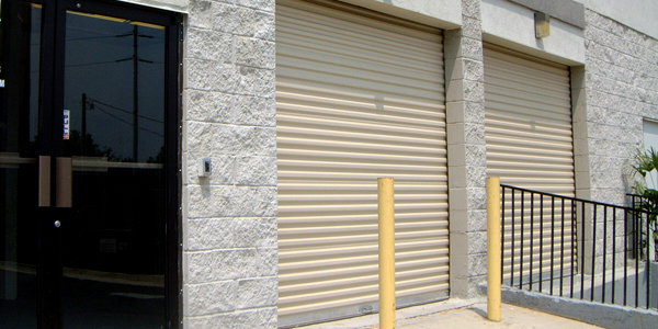 Two tan commercial rolling garage doors on a building, installed or repaired by USA Doors in Doral, FL.