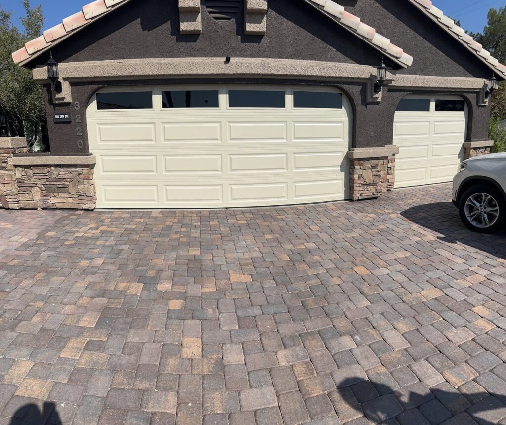 Two cream-colored panel garage doors on a residential home, showcasing work by NV Pro Garage Doors in Las Vegas, NV.