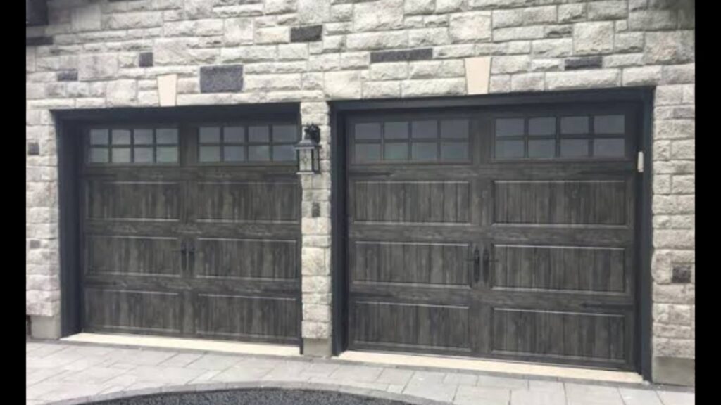 Two dark grey wood-grain style garage doors with windows installed by Elite Garage Door Service & Repair in Billings, MT.