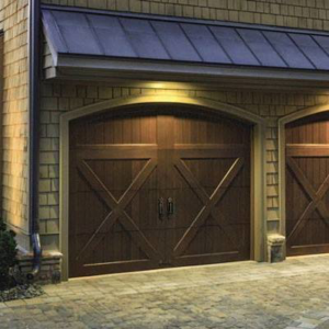 Two dark wooden garage doors with X-bracing and arched tops installed by Advance Garage Door, Inc. in Fargo, ND.