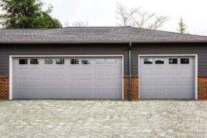 A modern home with two grey panel garage doors, showcasing work by Overhead Door Co of Missoula in Missoula, MT.