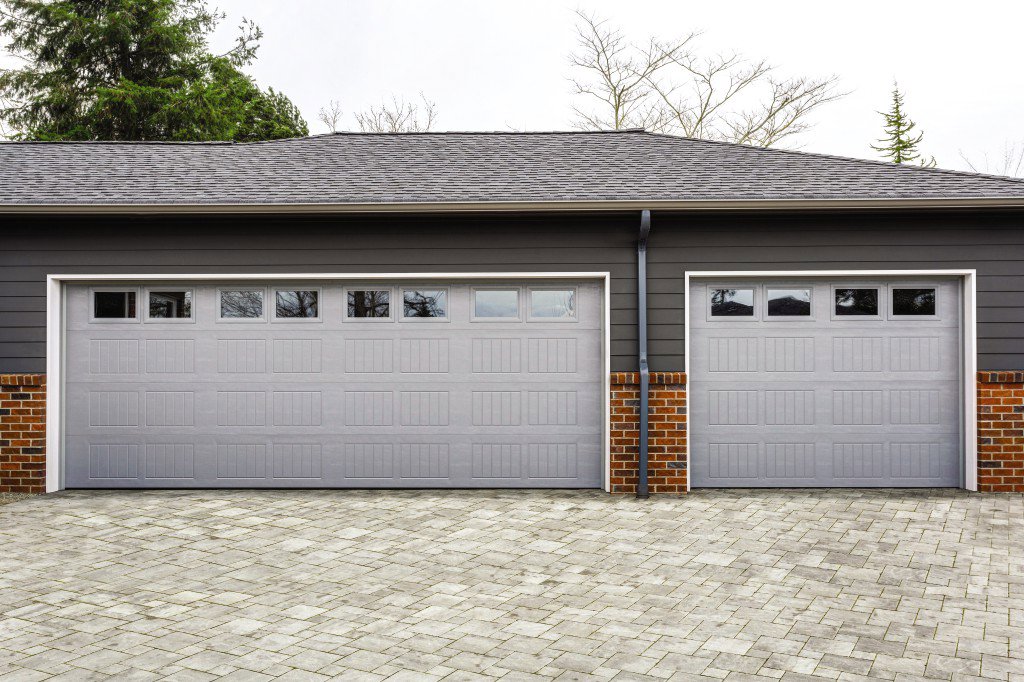 A modern home with two grey panel garage doors, showcasing work by Overhead Door Co of Missoula in Missoula, MT.