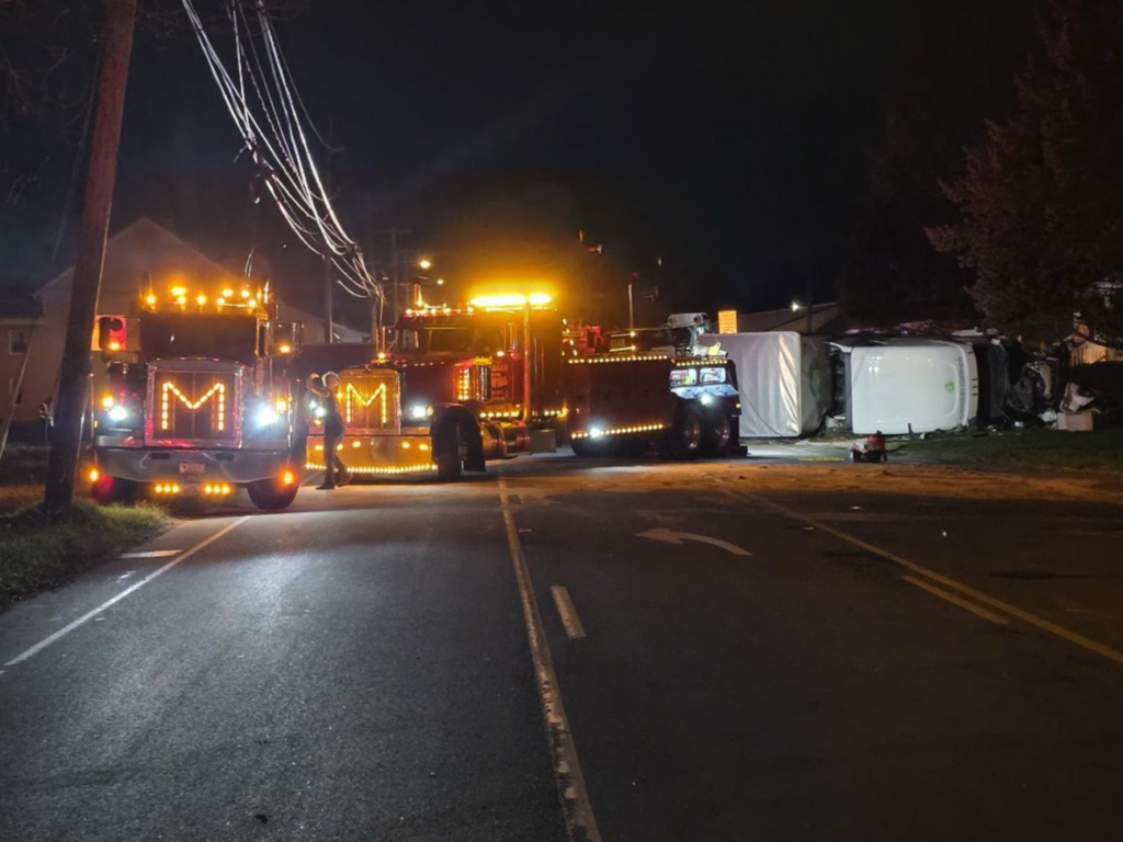 Two heavy-duty tow trucks on site for a large vehicle recovery operation at night by Alliance Towing in Lancaster, PA.