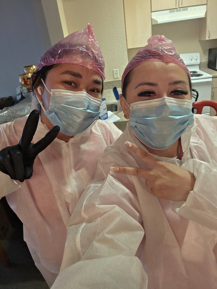 Two professional house cleaners in uniform and masks posing for a photo at Expert Cleaners LLC in Jacksonville, FL.