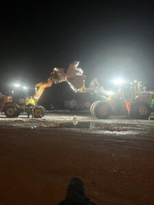 Two heavy-duty loaders working together to move large piles of snow at night by Turf Pro Lawn Care & Snow Removal in Green Bay, WI.