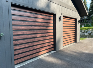Two modern garage doors with horizontal wood-grain panels and dark frames installed by Steelhead Doors, Services Available In.