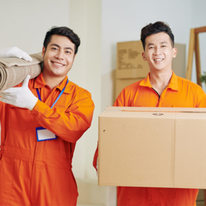 Two professional movers carrying a rolled rug and a box for Delivery on Demand in Scottsdale, AZ