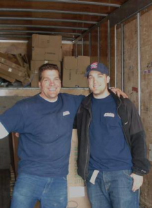 Two smiling movers standing inside a truck with boxes, ready for a job with A Few Good Movers in Minneapolis, MN.