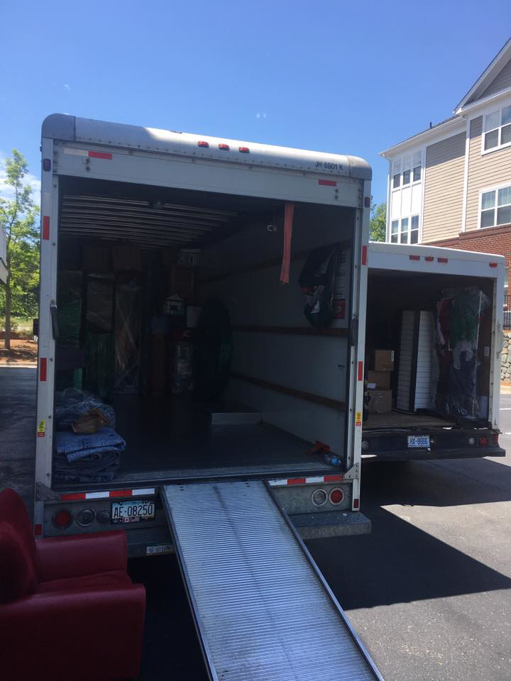 Two moving trucks, one with a ramp down, loaded with furniture and boxes by Wright-A-Way Transportation Services in Cary, NC.