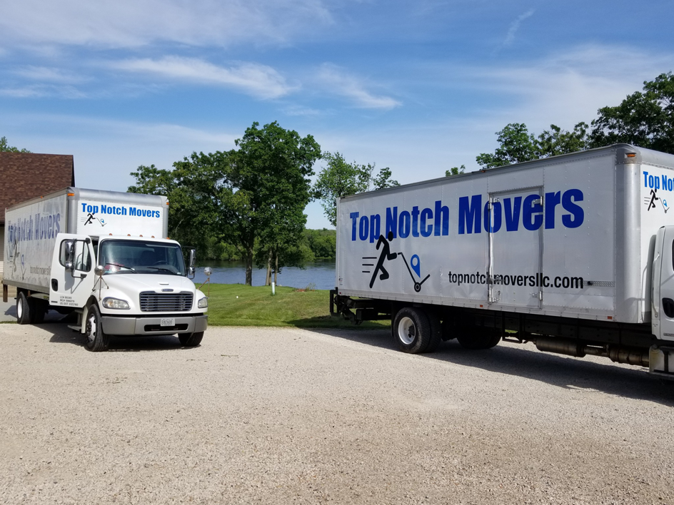 Two Top Notch Movers trucks parked by a lake, ready for a moving job in Lauderhill, FL.