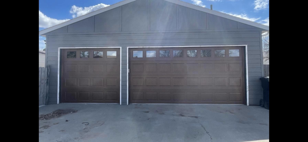 Two newly installed brown garage doors on a residential property by PS Garage Doors of Williston, ND.