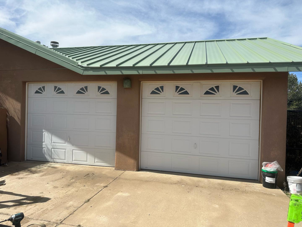 Two new white garage doors with decorative windows installed by Espada Garage Door and Gate, LLC in Las Cruces, NM.