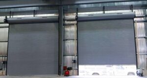 Two large grey Raynor rolling steel doors installed inside a commercial building by PS GARAGE DOORS in Grand Forks, ND