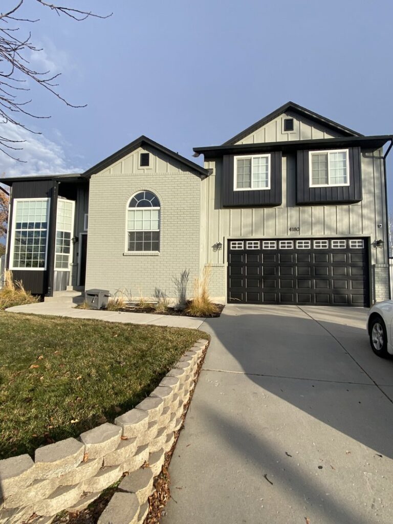 A two-story house showcasing stylish gray horizontal siding with contrasting black trim by New Look Siding in Midvale, UT.