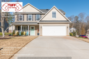 A two-story residential house featuring tan vinyl siding and dark shutters, installed by Tuff Vinyl Siding Montgomery Al in Montgomery, AL.