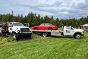 Two Solid Choice Towing trucks, one towing a red sedan, demonstrating professional towing services in Wasilla, AK.