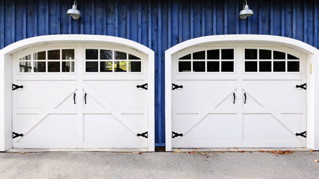 Two newly installed white arched garage doors with decorative hardware by PS GARAGE DOORS in Grand Forks, ND