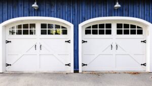 Two newly installed white arched garage doors with decorative hardware by PS GARAGE DOORS in Grand Forks, ND