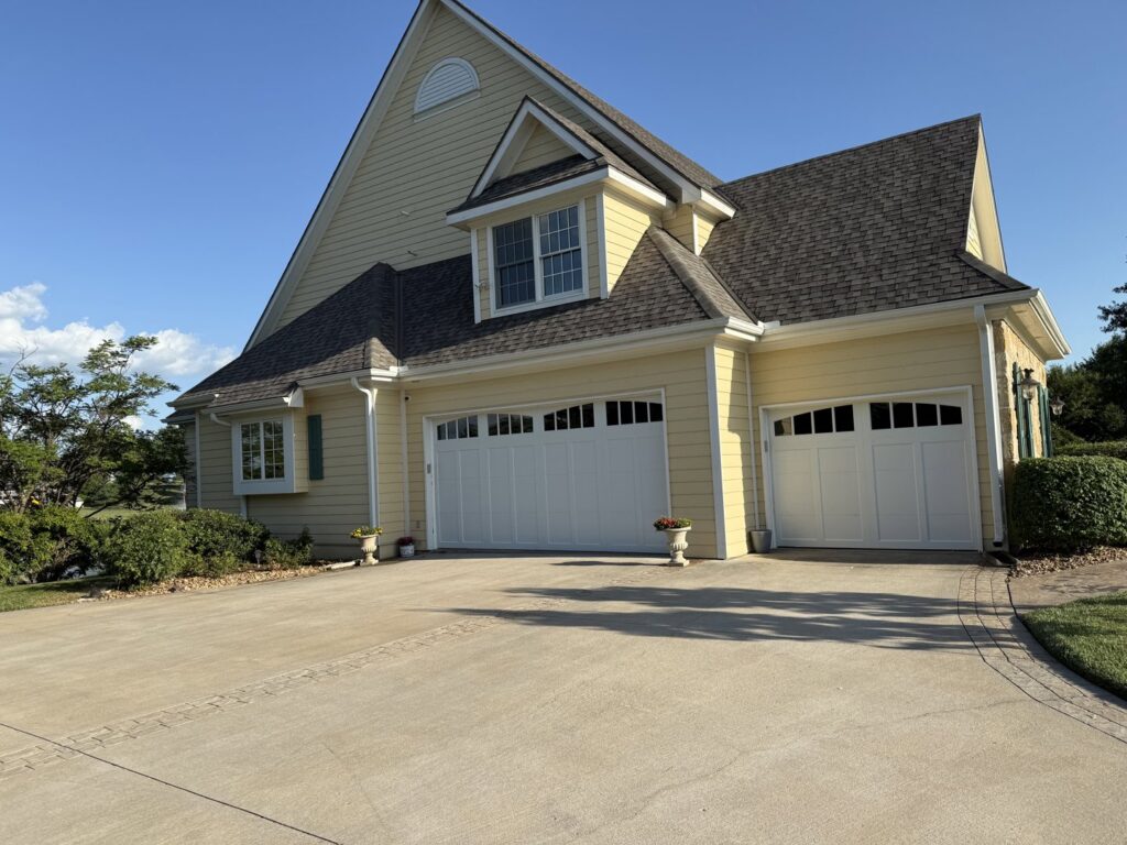 Two white carriage-style garage doors with decorative windows installed by ABC Garage Doors KC in Kansas City, KS.
