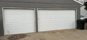 Two classic white panel garage doors on a residential home by PS Garage Doors of Williston, ND.